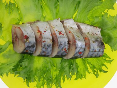 Tuzlu uskumru ve taze salata. Parçalar sarı arkaplanda yatıyor