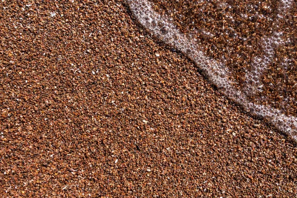 Eine kleine Welle läuft über einen Sandstrand. Hintergrund für ein Banner für Tourismus und Erholung — Stockfoto