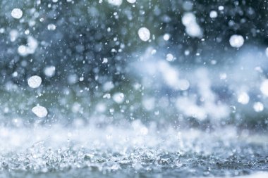 Yağmur mevsiminde yere düşen yağmur damlalarının mavi renk tonu