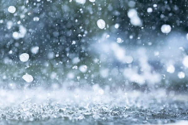 Yağmur mevsiminde yere düşen yağmur damlalarının mavi renk tonu