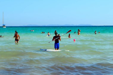 Haziran 2019 'da Sa Rapita' da deniz kıyısında kürek çeken bir adam.)