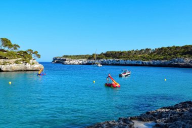Denizin mavi kıyısı, günbatımı ışınlarında insanları oynuyor.