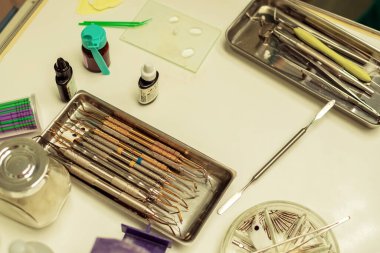 Açık renkli masada farklı dişçi aletleri var.