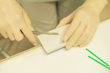 Diş hekiminin elleri, dişçi kliniğinde kapama için ilaç hazırlıyor.