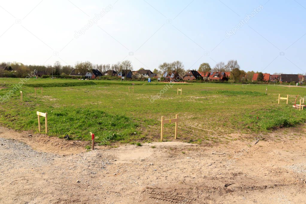 Building lot site with grass after stakeout measurement survey ready for construction, Germany