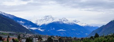 Mountain panorama with snowcapped mountains and summit Laaser Spitze (Orgelspitze) in Ortler Alps and valley Etschtal on a cloudy day in autumn in South Tyrol, Italy
