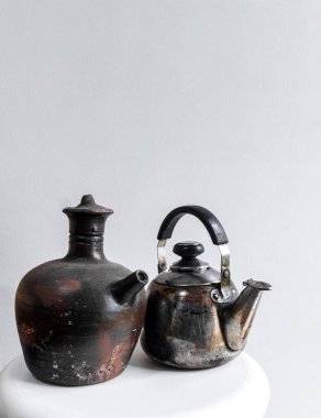 Clay 'in su testisi ve paslanmaz su ısıtıcısı beyaz arka planda izole edilmiş.