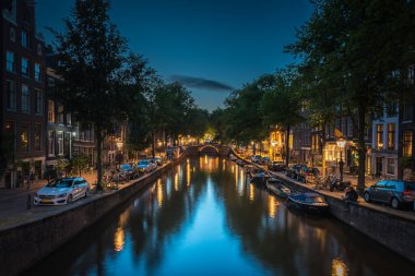 Şehrin ışıkları gece vakti kanal suyuna yansıdı, Amsterdam, Hollanda