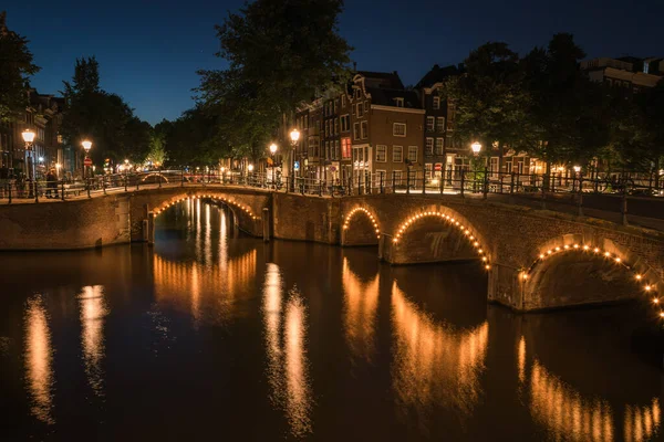 Hollanda 'nın Amsterdam kentindeki kanal suyuna yansıyan şehir ışıklarının görüntüsü