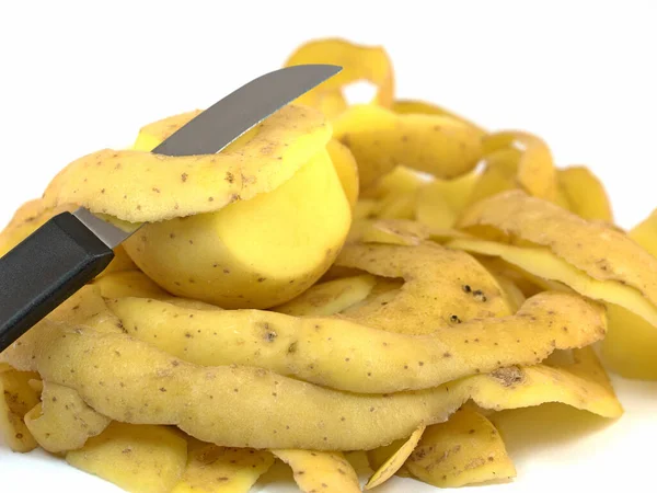 Beyaz arka planda soyulmuş patates ve mutfak bıçağı.
