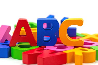 Beyaz arkaplana karşı renkli ahşap harfler.