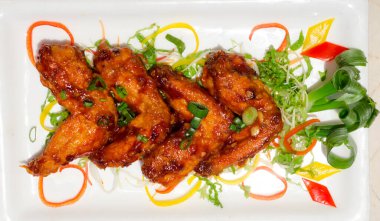 Tabağa konmuş kızarmış tavuk kanatları.