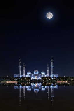 Sheikh zayed grand mosque illuminated at full moon night clipart