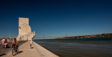 Lizbon, Portekiz 07 / 12 / 2010: Tagus nehrinin kuzey kıyısında, Tagus nehri, 25 de Abril köprüsü ve Almada nehrinin yanındaki ünlü keşiflerin yer aldığı bir manzara resmi. 