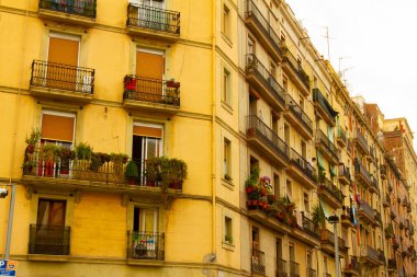 Barcelona / İspanya 05 / 01 / 2010 Barcelona şehir merkezinde bir apartman kompleksi. Bu apartmanın sarı bir cephesi, dekoratif saksı çiçekleriyle dolu dar balkonları var. Eski bir bina..