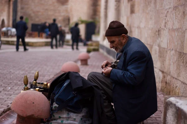 土耳其阿达纳 2009年12月26日 一位正在街上用老式鞋类工具箱工作的老年鞋油抛光师的近照 他坐在历史城区的工作台旁边的凳子上 — 图库照片