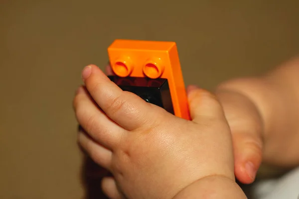 Close up image of an infant baby\'s hands as he or she is trying to put together blocks. Image is useful to demonstrate motor development, fine motor skills, balance, precision, baby growth themes