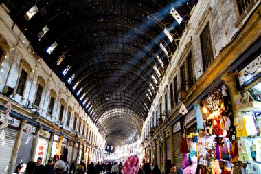 Şam, Suriye 03 / 28 / 2010: Orta Şam 'daki en büyük pazar yeri olan Al-Hamidiyah Souq' un içi. Resim, güneş ışığının pencerelerden ve kurşun deliklerinden geçtiği tavanı gösteriyor.
