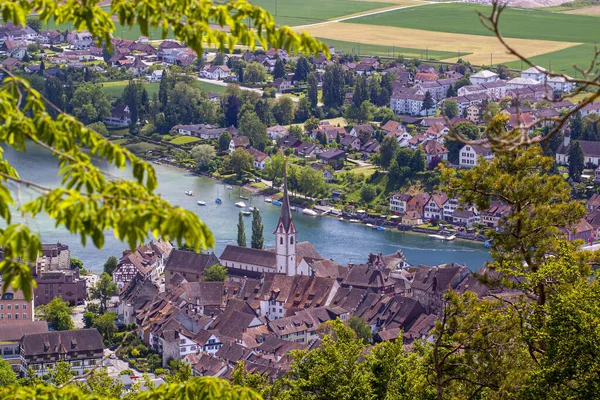 İsviçre 'de Ren nehrinin kıyısındaki tarihi Stein am Rhein kasabasının tepeden görünen manzarası. Görüntü, St. George 's Manastırı' nın yanı sıra eski evlerin çatılarını da içeriyor.