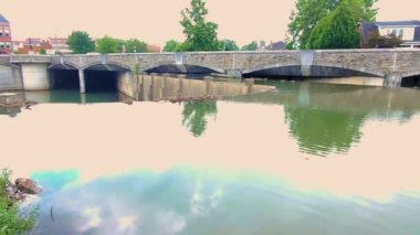 Güneşli bir günde Frederick, Maryland 'deki Carroll Creek' in panoramik bir manzara görüntüsü. Baker Parkı 'ndan geçen derenin görüntüleri. Taştan bir köprü ve yakınlardaki evler de görülüyor..