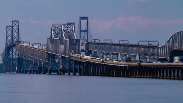 在切萨皮克湾大桥 Chesapeake Bay Bridge 上显示高峰时段交通的时间间隔录像 它详细地展示了有柱子和吊索的大桥 以及从下面经过的船只 — 图库视频影像