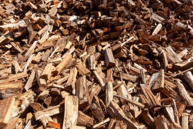 Farklı şekil ve boyutlara kesilmiş ve düzensiz bir şekilde dağılmış ahşap kütüklerin arka plan görüntüsü. Bu yakın plan resim ahşap, ormancılık, kereste ve çevre için uygun bir konsept görüntüdür.. 