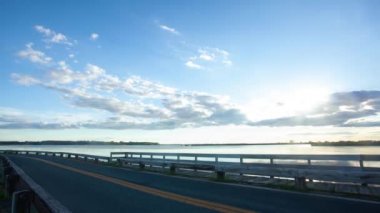 Doğu Yakası Adası 'nı Maryland' in doğu kıyısına bağlayan köprünün üzerinden geçen geniş açılı günbatımı hızlandırma görüntüleri. Chesapeake Körfezi 'nde bulutlar ve arabalar hareket halindeyken gün batımını gösteren görüntüler 