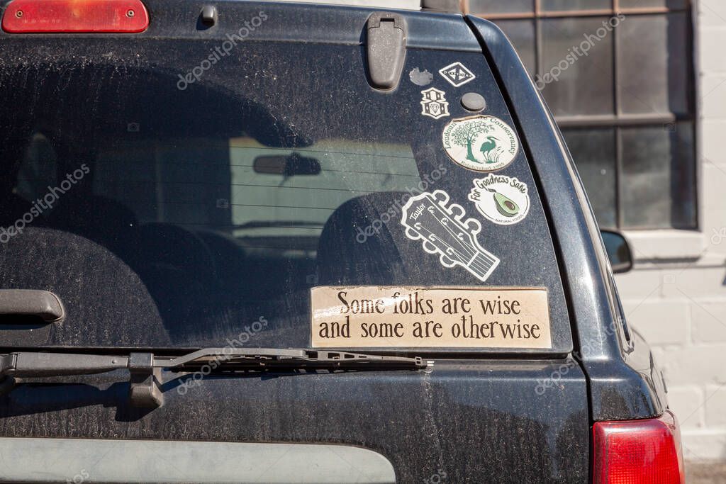 Berryville, VA, USA 09/27/2020:  a car's rear windshield that has a bunch of car window stickers. One is a funny, creative quote from Tobias Smollett : 