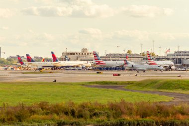 Washington DC, ABD 10 / 02 / 2020: Reagan Ulusal Havaalanı 'nın terminal binasının önünde yükleme ve boşaltma için bekleyen farklı havayollarından gelen uçakların görüntüleri. Yer ekibi aktif olarak çalışıyor..