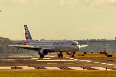 Washington DC, ABD 10 / 03 / 2020: Ronald Reagan Ulusal Havaalanı. American Airlines tarafından işletilen bir Airbus A321 yolcu uçağı pistte manevra yapıyor. Jet yakıtının buharlaşması bulanıklığa neden olur.