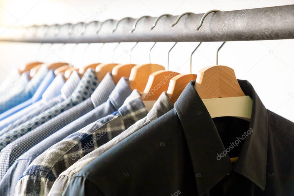 Row of mens shirts in blue colors on hanger