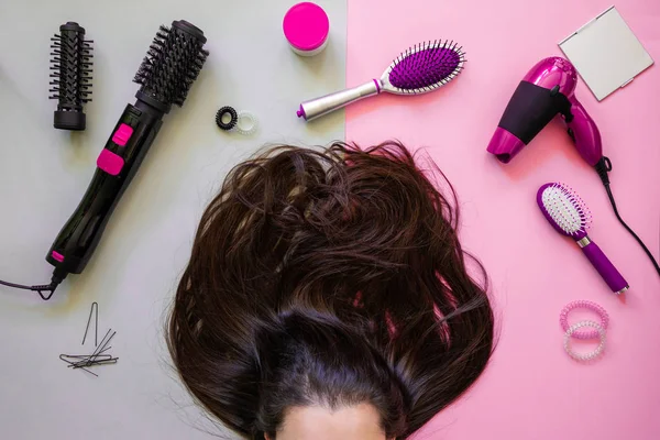 Narzędzia profesjonalne fryzjerskie i brunetka na różowym tle — Zdjęcie stockowe