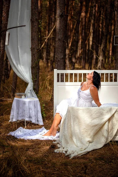 Vrouw wordt wakker in bed in de ochtend op de achtergrond van de natuur van bos — Stockfoto