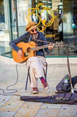 Corfu, Yunanistan - 16.10.2018: Sokak müzisyen Corfu town, Yunanistan parkında gitar çalıyor