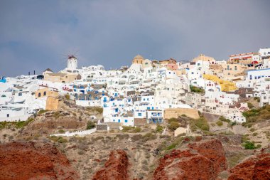 Beyaz evler ile Oia köy görünümü üzerinde kırmızı kayalar caldera Santorini Island, Yunanistan