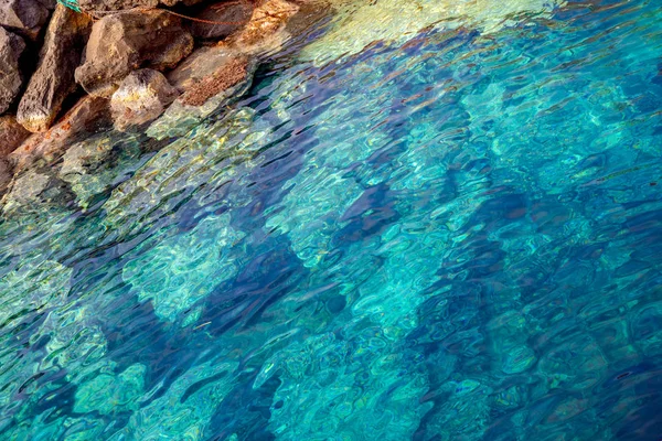 希腊圣托里尼岛的蓝色清澈水和岩石 — 图库照片
