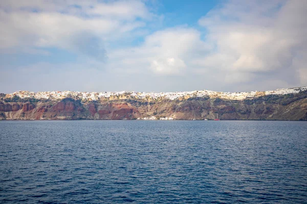 Vista del pueblo de Oia con casas blancas sobre rocas rojas caldera de la isla de Santorini, Grecia — Foto de Stock