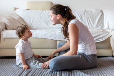 Sevimli küçük çocuk annesi ev ile oynarken Down sendromlu