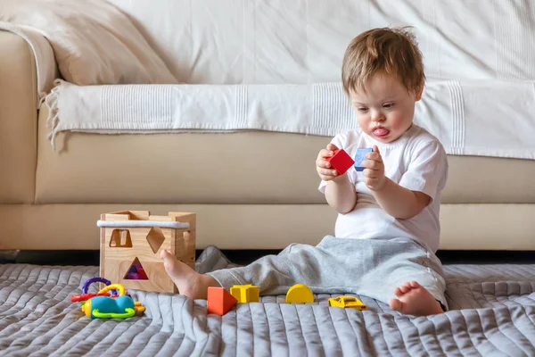 Carino piccolo ragazzo con giù sindrome giocare con giocattolo in casa — Foto Stock