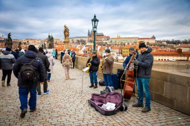 Prag, Çek Cumhuriyeti - 06.01.2019: Prag'da kış gününde Charles Köprüsü'nde müzisyenler ve turistler, Çek Cumhuriyeti