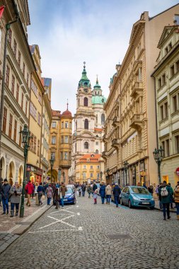 Prag, Çek Cumhuriyeti - 06.01.2019: Saint Nicolas Kilisesi veya kostel svateho Mikulase, Prag, Çek Cumhuriyeti'nde insanlarla mostecka caddesinden görünümü