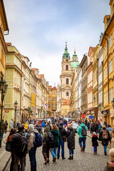 Prag, Çek Cumhuriyeti - 06.01.2019: Saint Nicolas Kilisesi veya kostel svateho Mikulase, Prag, Çek Cumhuriyeti'nde insanlarla mostecka caddesinden görünümü