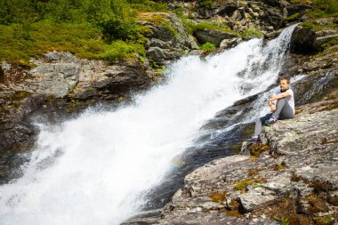 Dalsnibba mountain, Norveç yakınındaki Geiranger Vadisi'nde şelale yanında genç adam
