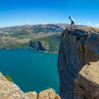 Preikestolen üzerinde duran ve fjerd, Preikestolen - Norveç dağlar, ünlü cliff üzerinde seyir uzun yürüyüşe çıkan kimse