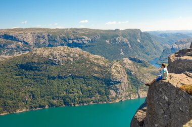 Preikestolen üzerinde duran ve fjerd, Preikestolen - Norveç dağlar, ünlü cliff üzerinde seyir uzun yürüyüşe çıkan kimse