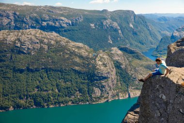 Preikestolen üzerinde duran ve fjerd, Preikestolen - Norveç dağlar, ünlü cliff üzerinde seyir uzun yürüyüşe çıkan kimse