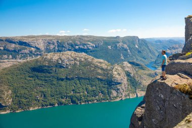 Preikestolen üzerinde duran ve fjerd, Preikestolen - Norveç dağlar, ünlü cliff üzerinde seyir uzun yürüyüşe çıkan kimse