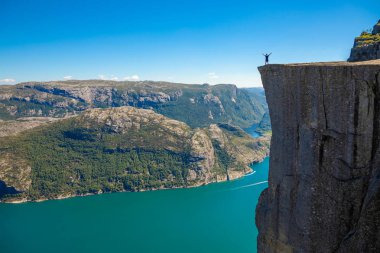Preikestolen üzerinde duran ve fjerd, Preikestolen - Norveç dağlar, ünlü cliff üzerinde seyir uzun yürüyüşe çıkan kimse