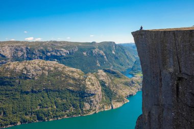 Preikestolen üzerinde duran ve fjerd, Preikestolen - Norveç dağlar, ünlü cliff üzerinde seyir uzun yürüyüşe çıkan kimse