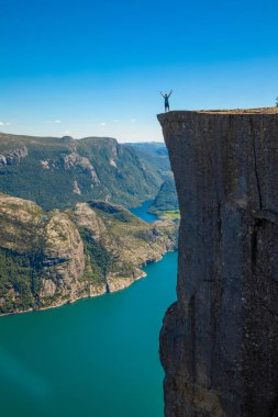 Preikestolen üzerinde duran ve fjerd, Preikestolen - Norveç dağlar, ünlü cliff üzerinde seyir uzun yürüyüşe çıkan kimse